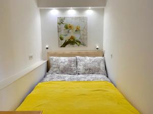 a small bedroom with a yellow bed in it at Villa Yadranka in Strunjan