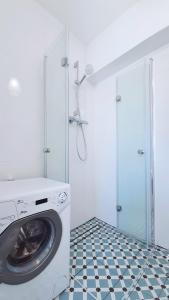 een wasmachine in een badkamer met een tegelvloer bij MajaMi in Gdańsk