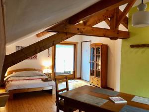 a bedroom with a bed and a table in a room at L'Ancolie in Le Reposoir