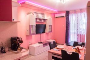 a dining room with a table and a tv on a wall at Apartment Nicole in Varna City