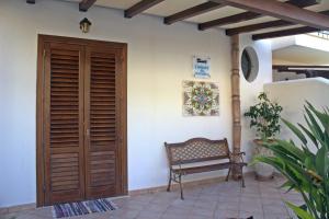 マカリにあるCamere da Mariolinaの中庭の木製の扉とベンチ