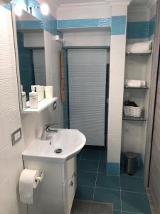 a bathroom with a white sink and a mirror at LA CASA DI NANA' in Naples