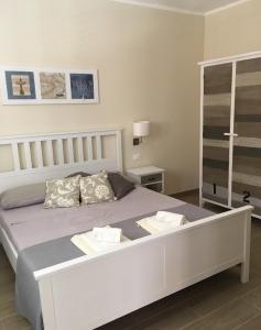 una camera da letto con un grande letto bianco con due cuscini di Camere a Sud - Lampedusa a Lampedusa