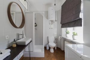 łazienka z umywalką, toaletą i lustrem w obiekcie House Apartments Centrum Poznań w Poznaniu +37 zdjęć
