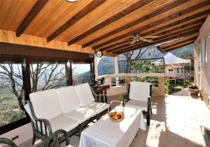 een patio met witte stoelen, een tafel en ramen bij RELAX HOUSE in Solin