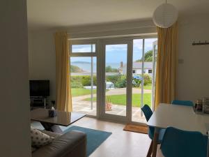 a living room with a table and a sliding glass door at Flat 7, Tremorvah Court in Falmouth