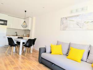 a living room with a couch and a table with yellow pillows at Blue Mare Apartamenty U Tomka in Łukęcin