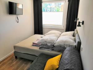 a bedroom with a bed with pillows and a window at Blue Mare Apartamenty U Tomka in Łukęcin +134 photos