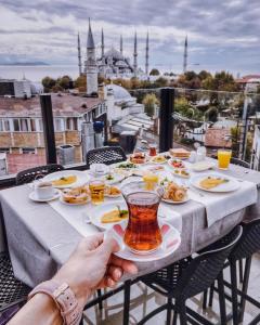 ein Tisch mit Tellern voller Essen und einer Tasse Tee in der Unterkunft Sura Design Hotel & Suites in Istanbul