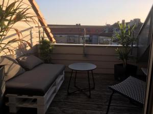 a balcony with a couch and a table on a balcony at Fair Messe Rooftop Loft in Nürnberg in Nuremberg