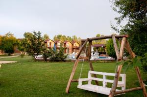 - une balançoire en bois dans une cour avec une maison dans l'établissement Agva Gizemli Nehir Hotel, à Ağva