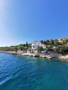 une maison sur la rive d'une masse d'eau dans l'établissement Apartmani Mila, à Starigrad-Paklenica