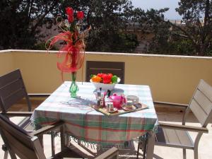 uma mesa com um vaso de flores e uma taça de fruta em Don Nicola Residence em Salve