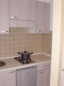 uma cozinha com armários brancos e uma panela no fogão em Don Nicola Residence em Salve