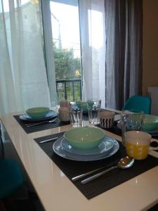 une table avec des assiettes, des bols et des verres dans l'établissement Apartment Simply Rodin, à Kaštela