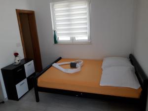 a small bedroom with a bed with a window at Studio Apartment Sanja 4 in Neum
