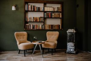 two chairs and a table in a room with a book shelf at Vila Koman Jezersko in Zgornje Jezersko +23 photos