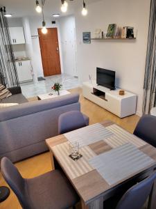 a living room with a couch and a table at Apartament Alfa in Toruń