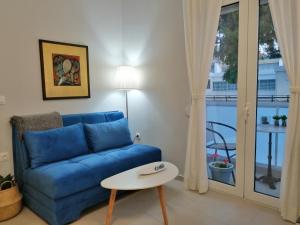 a living room with a blue couch and a table at Personal Holiday Homes in Rethymno Town