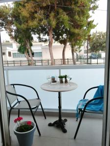 a table and chairs on a balcony with a window at Personal Holiday Homes in Rethymno Town