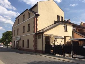 a white building with a fence next to a street at Nowy Apartament CENTRUM - faktura VAT in Włodawa