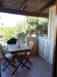 a wooden table and chairs on a patio at CASA BIJOUX in Olbia