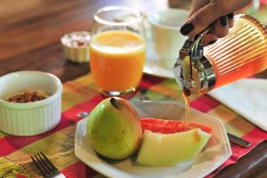a person is pouring juice onto a plate of fruit at Pousada Manacás in Cavalcante +41 photos