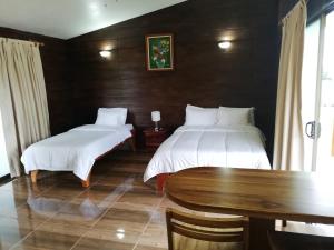 Habitación con 2 camas, mesa y mesa. en Cabañas Bambú, en San Vito