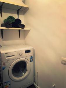 a laundry room with a washing machine and shelves at Lux Apartament in Zalău