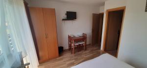 a bedroom with a bed and a desk and a television at Rooms Jure Sabljak in Grabovac
