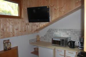 uma cozinha com um micro-ondas e uma televisão na parede em Café Landerl em Matrei in Osttirol