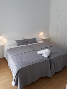 a bedroom with a large bed with gray sheets at Casa Adro in Melide