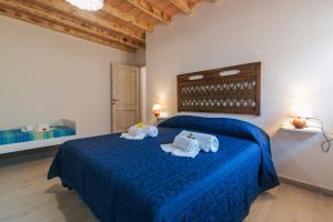 a bedroom with a blue bed with towels on it at Sardinia Suite Apartment Dorgali in Dorgali