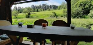 a wooden table with three glasses on top of it at Chalupa U Studánky in Adršpach