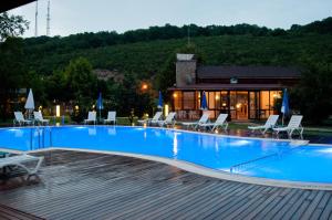 a large swimming pool with chairs and a house at Agva Gizemli Nehir Hotel in Ağva