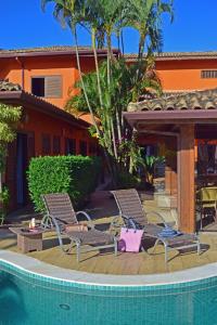 a couple of chairs sitting next to a swimming pool at Pousada Mais Bella in Ilhabela