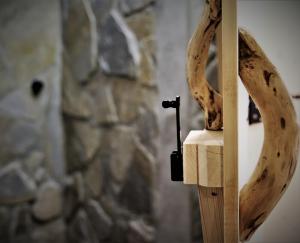 drewniany stojak z kawałkiem drewna i kamienną ścianą w obiekcie Willa Gawra w Zakopanem