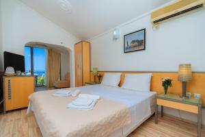 a hotel room with a bed and a television at Hotel Savojo in Petrovac na Moru