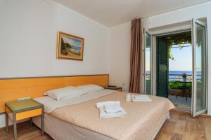 a bedroom with a bed with a view of the ocean at Hotel Savojo in Petrovac na Moru