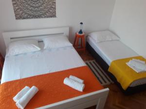 a bedroom with two beds with towels on a table at Apartments Pag Holiday in Pag