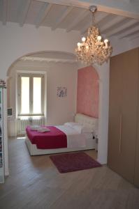 a bedroom with a large bed and a chandelier at Allegra Toscana - Affittacamere Guest house in Arezzo