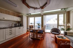 a kitchen and dining room with a table and chairs at Lofotveggen Panorama in Ballstad