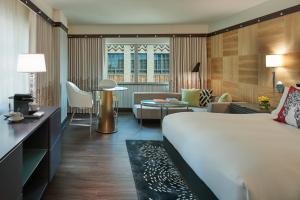 a hotel room with a bed and a living room at Sofitel Philadelphia at Rittenhouse Square in Philadelphia