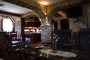 a living room with a table and a stone fireplace at Villa Serz in Bitola