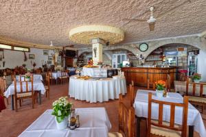 a dining room with white tables and chairs in a restaurant at Hotel Savojo in Petrovac na Moru