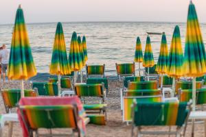 a group of beach chairs and umbrellas on the beach at Hotel Savojo in Petrovac na Moru