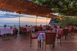 a restaurant with tables and chairs and a view of the ocean at Hotel Savojo in Petrovac na Moru