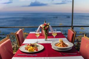 a table with two plates of food and wine glasses at Hotel Savojo in Petrovac na Moru +37 photos