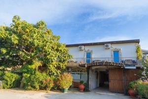 an apartment building with a balcony and a tree at Hotel Savojo in Petrovac na Moru