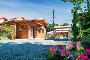 una casa con un jardín con flores delante en Chalés da Sinhá, en Penha